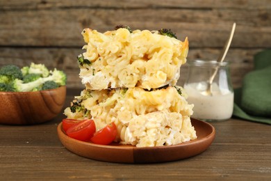 Photo of Tasty pasta casserole with cheese and broccoli served on wooden table, closeup