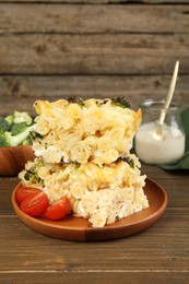 Photo of Tasty pasta casserole with cheese and broccoli served on wooden table