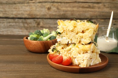 Photo of Tasty pasta casserole with cheese and broccoli served on wooden table