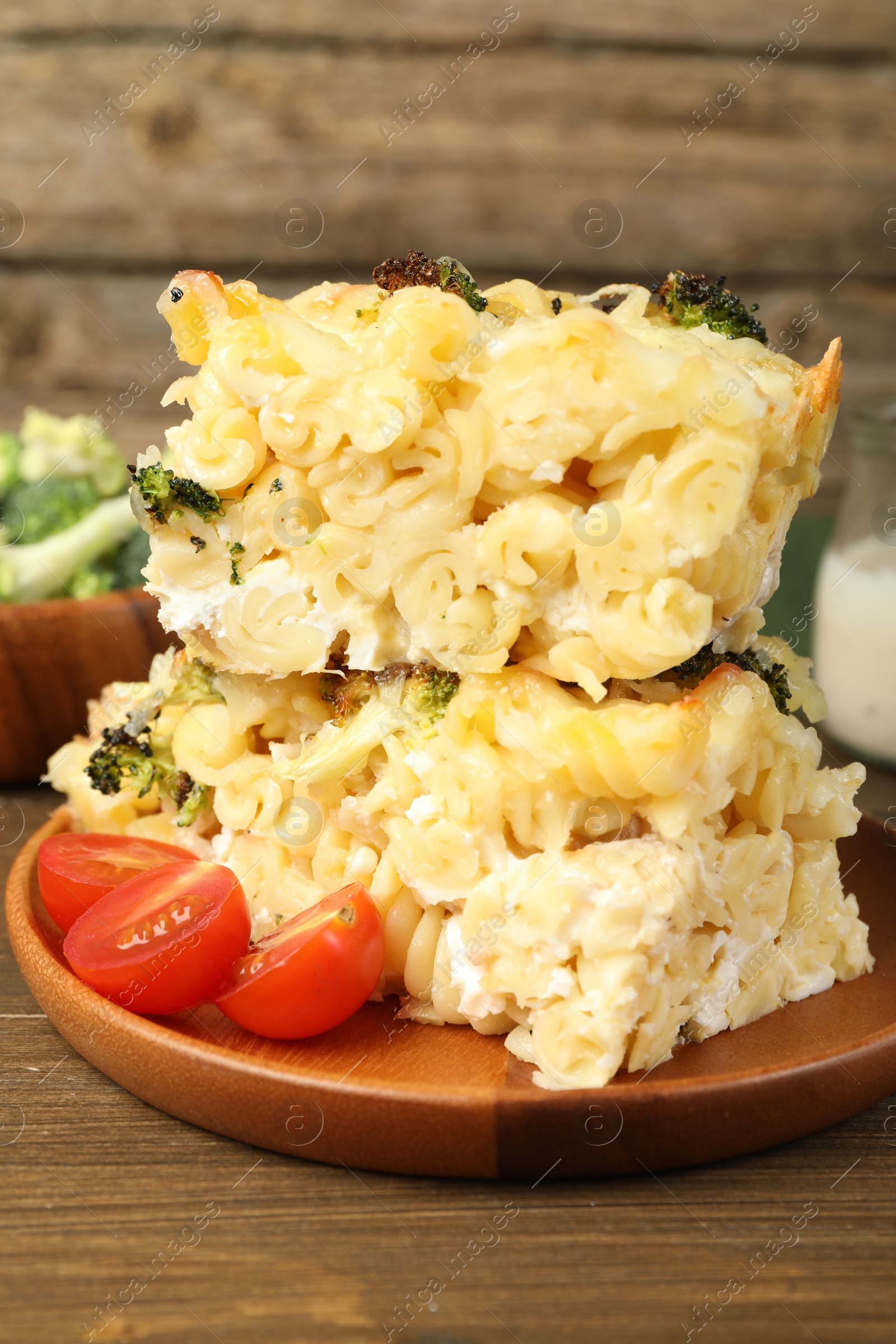 Photo of Tasty pasta casserole with cheese and broccoli served on wooden table, closeup