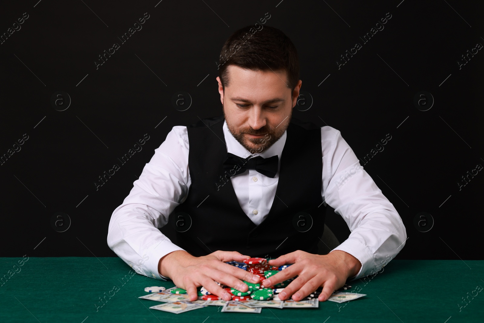 Photo of Professional croupier accepting bets at gambling table