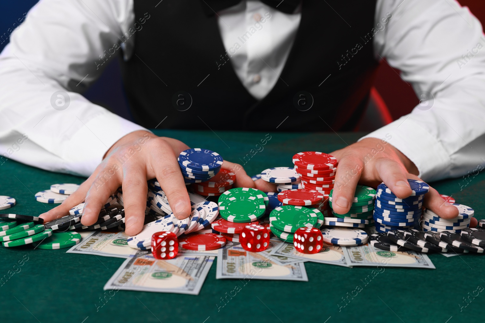 Photo of Professional croupier accepting bets at gambling table