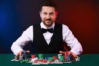 Photo of Professional croupier accepting bets at gambling table