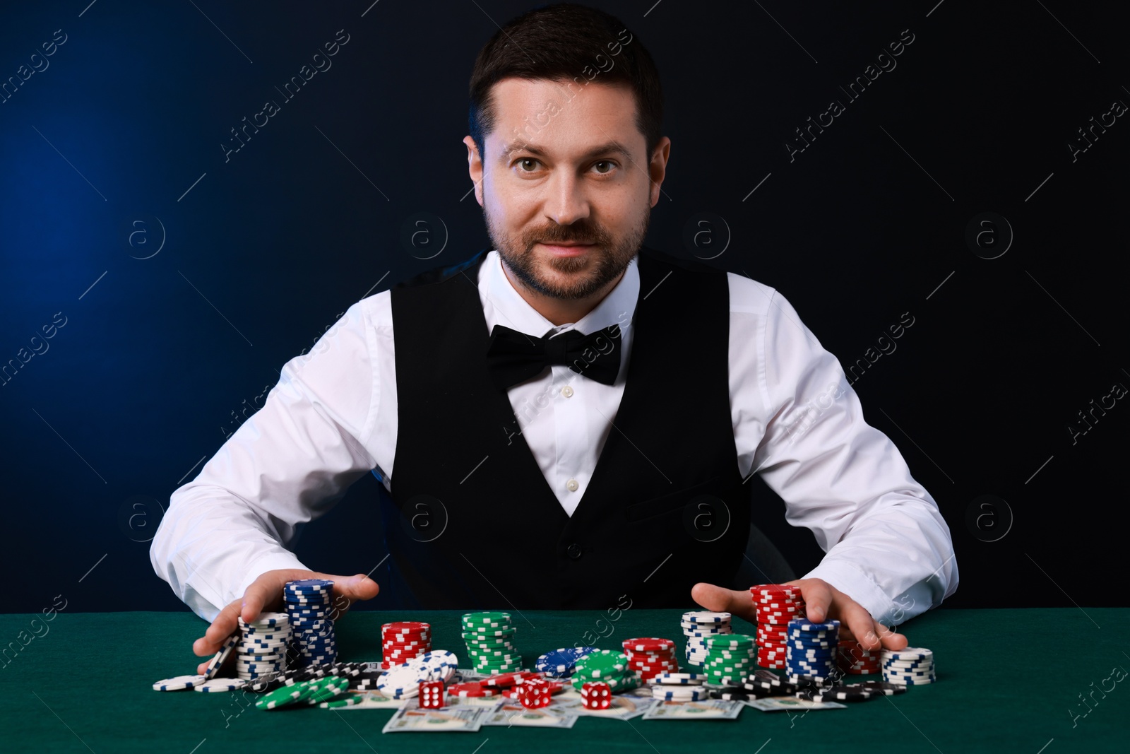 Photo of Professional croupier accepting bets at gambling table