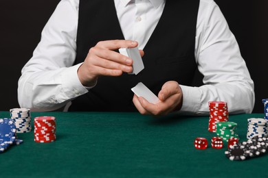 Photo of Professional croupier shuffling cards at gambling table, closeup