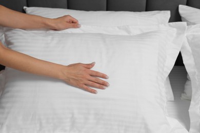 Photo of Woman changing clean bed linens at home, closeup