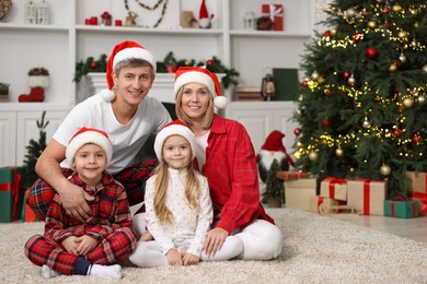 Portrait of happy family in Santa hats at home. Christmas holidays