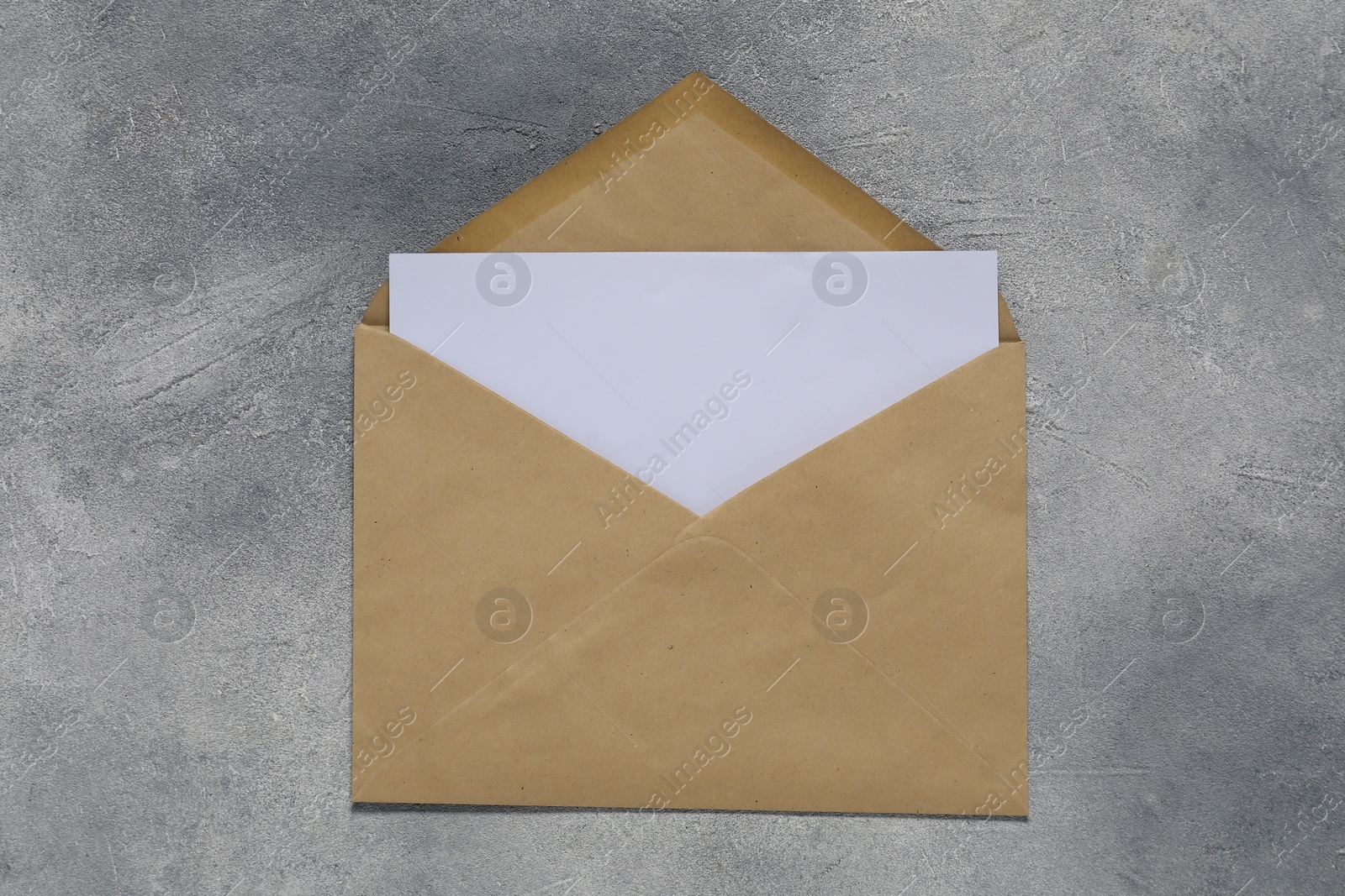 Photo of Paper envelope with letter on gray textured background, top view. Mockup for design