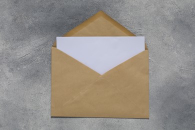 Photo of Paper envelope with letter on gray textured background, top view. Mockup for design