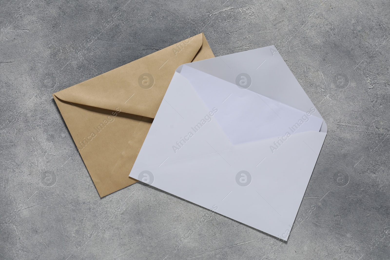 Photo of Paper envelopes with letter on gray textured background, top view. Mockup for design