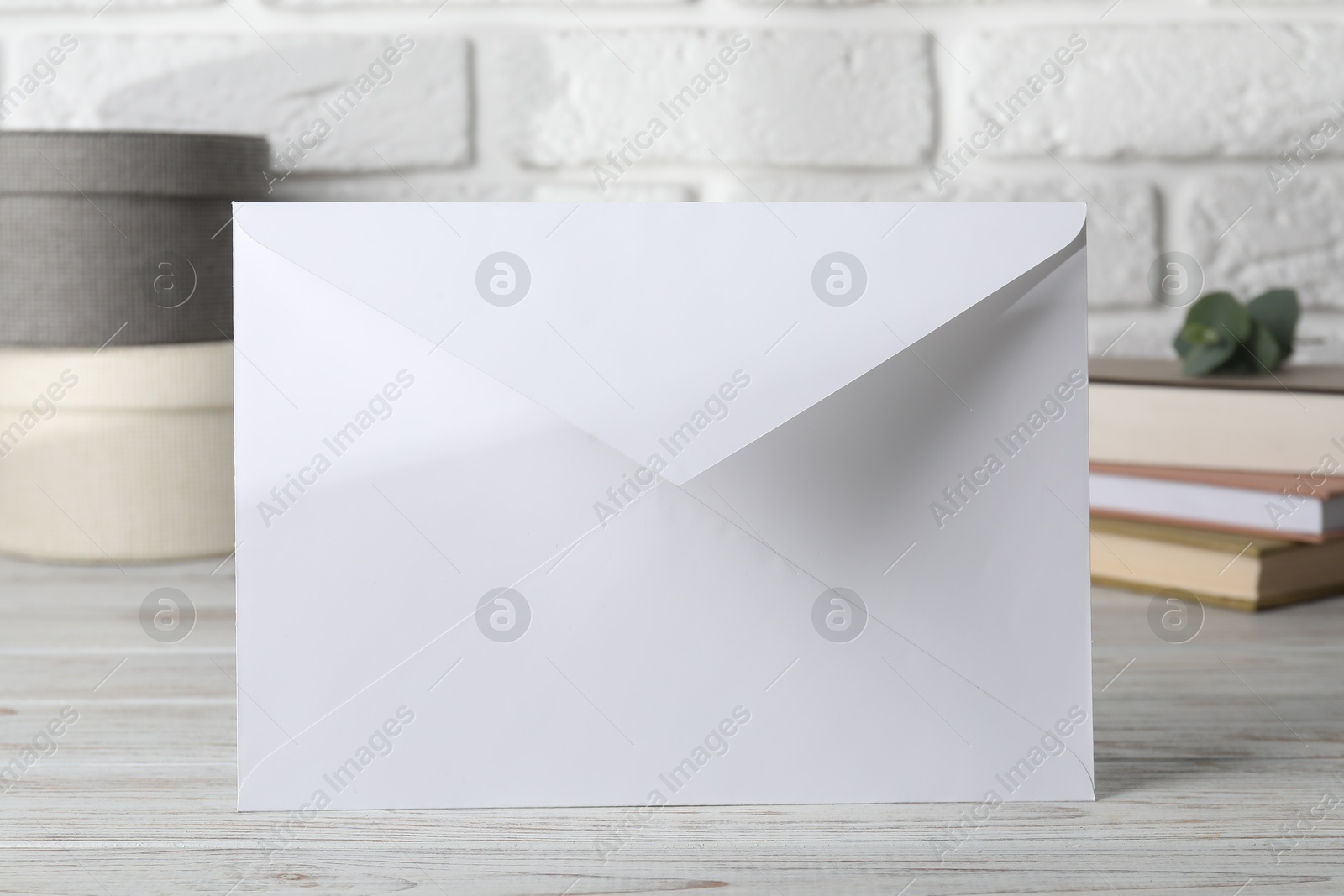 Photo of Paper envelope with letter on wooden table, closeup. Mockup for design