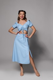 Photo of Happy pin-up woman posing on grey background