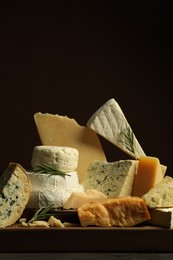 Photo of Different types of cheese and rosemary on table