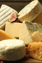 Photo of Different types of cheese and fig on table, closeup