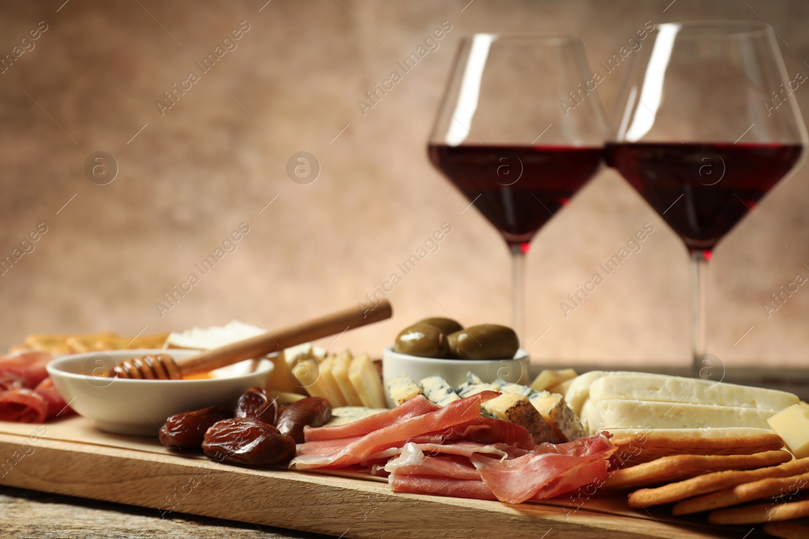 Photo of Different types of delicious cheese, other snacks and wine on table, closeup