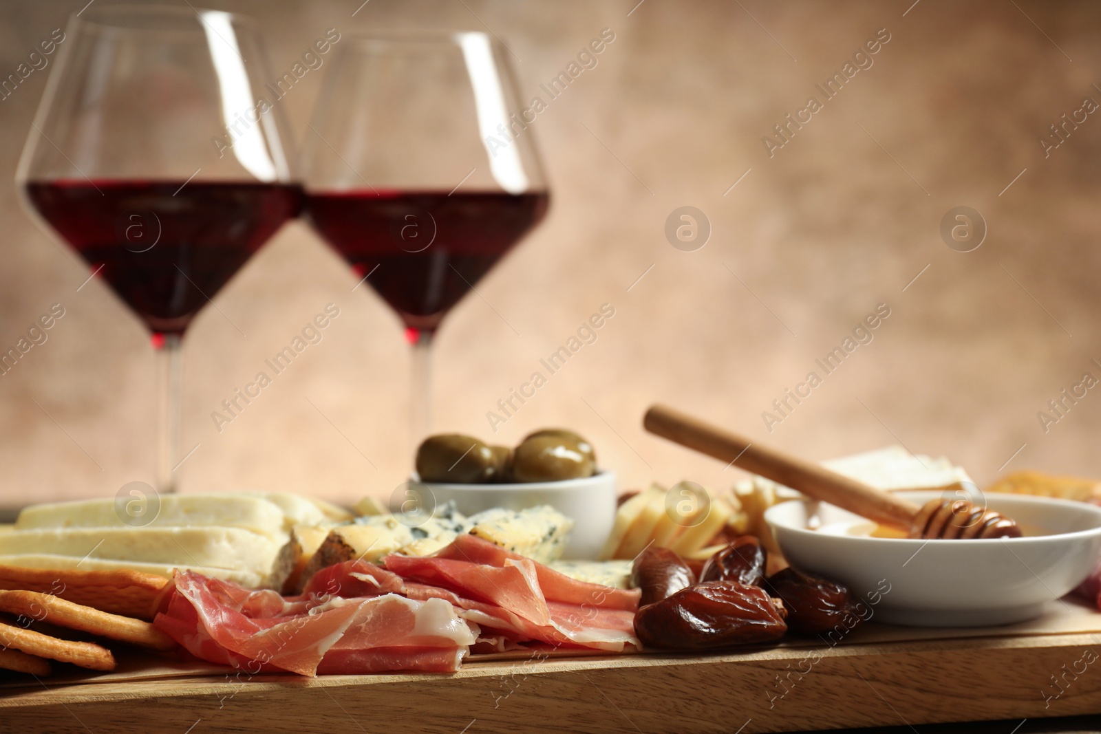 Photo of Different types of delicious cheese, other snacks and wine on table, closeup