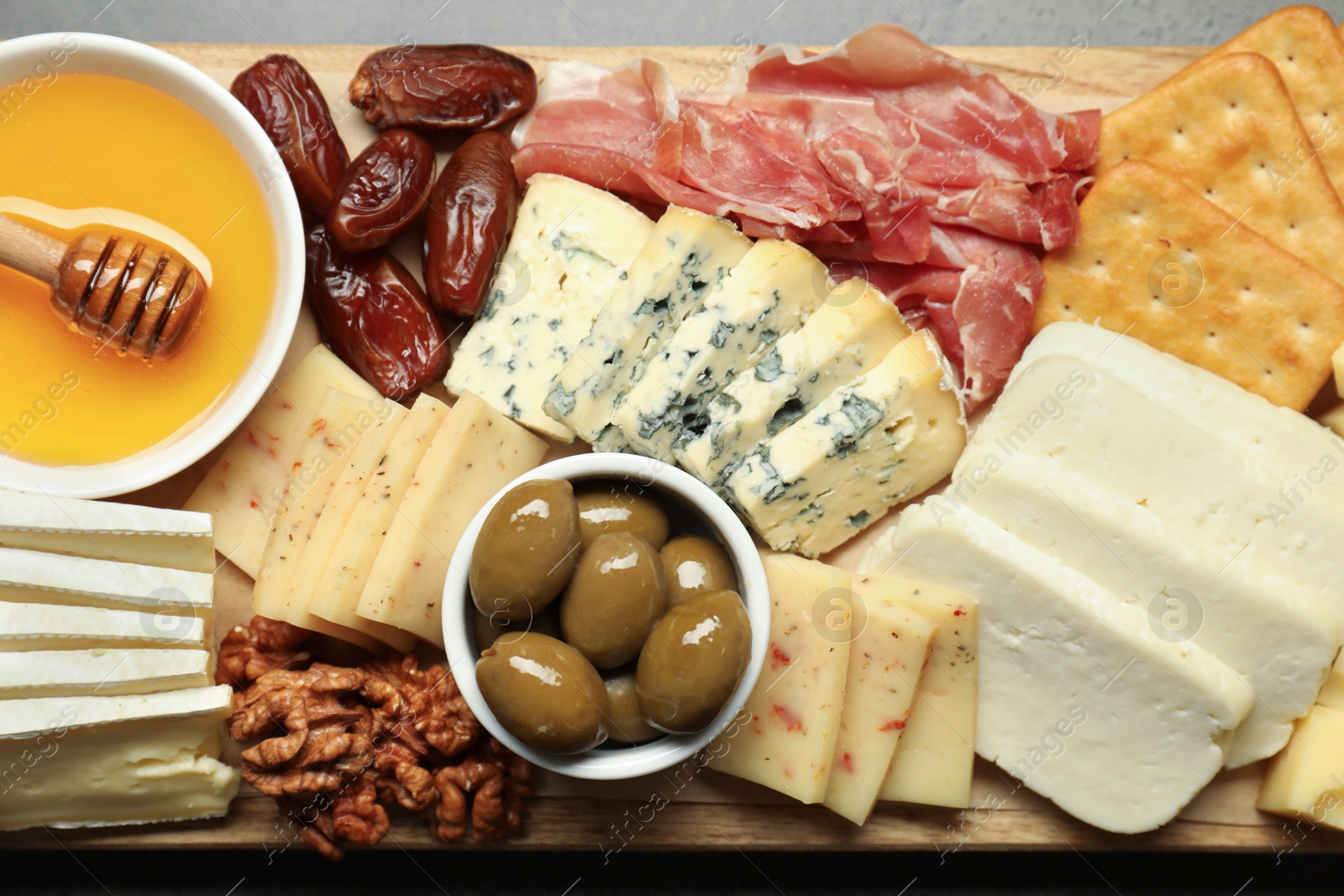 Photo of Different types of delicious cheese and other snacks on table, top view