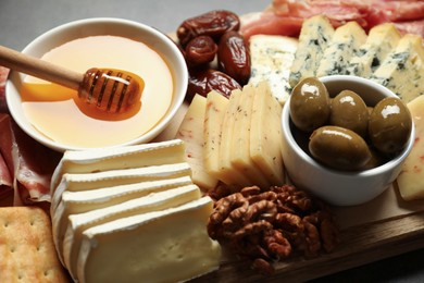 Photo of Different types of delicious cheese and other snacks on table, closeup