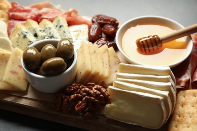 Photo of Different types of delicious cheese and other snacks on table, closeup