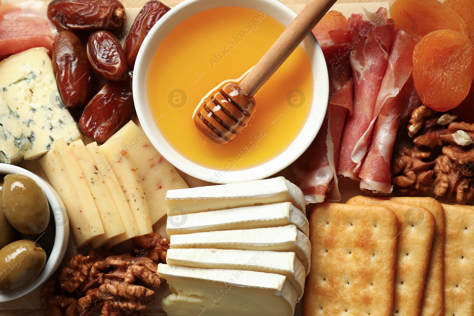 Photo of Different types of delicious cheese and other snacks as background, top view