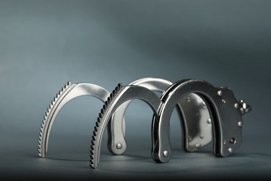 Photo of Metal chain handcuffs on grey background, closeup