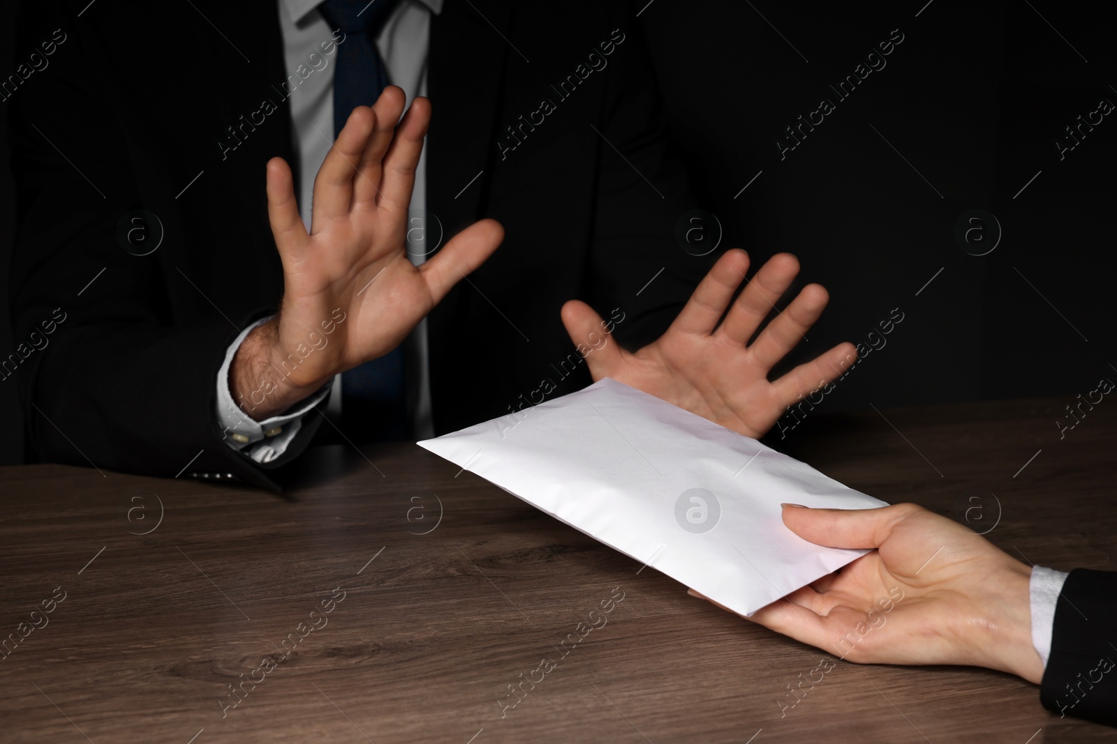 Photo of Corruption concept. Woman giving envelope with money to man at wooden table, closeup