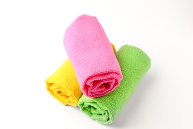 Photo of Rolled different microfiber cloths on white background