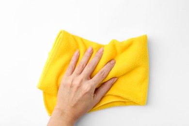 Photo of Woman with clean yellow microfiber cloth on white background, top view