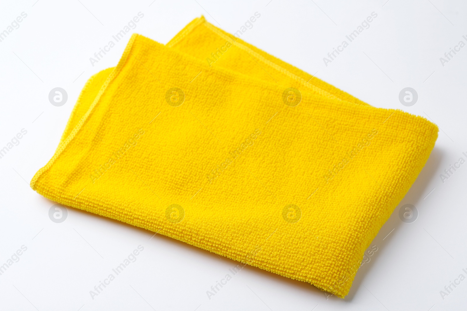 Photo of Clean yellow microfiber cloth on white background, closeup