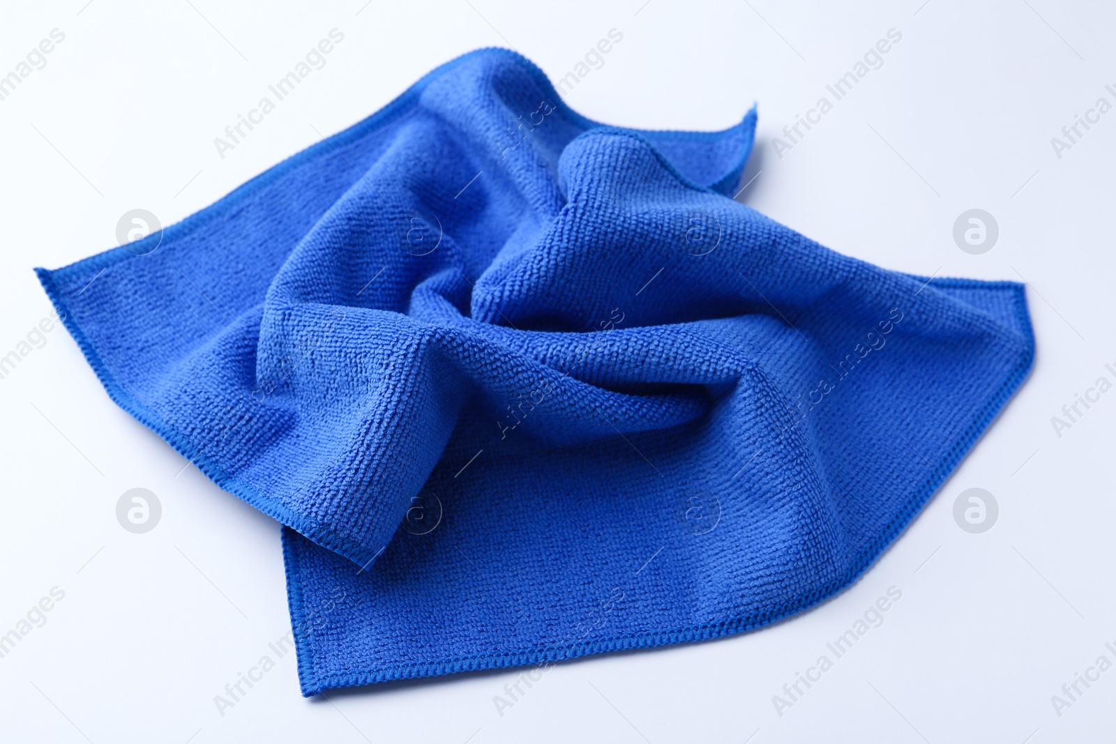 Photo of Clean blue microfiber cloth on white background, closeup