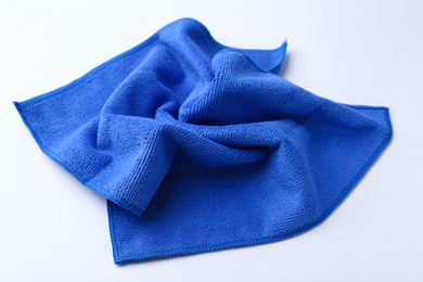 Photo of Clean blue microfiber cloth on white background, closeup