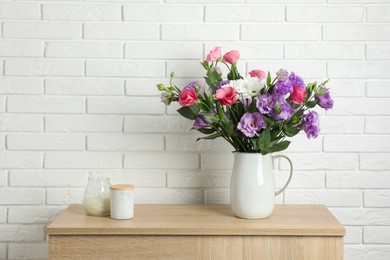 Photo of Vase with beautiful eustoma flowers on wooden chest of drawers