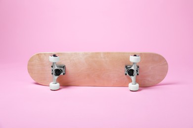 Photo of One skateboard on pink background. Sports equipment