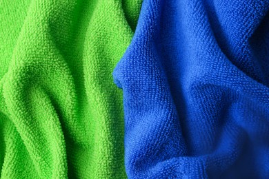 Photo of Clean green and blue microfiber cloths as background, top view