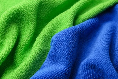 Photo of Clean green and blue microfiber cloths as background, closeup