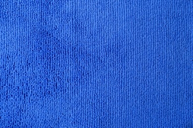 Photo of Clean blue microfiber cloth as background, top view