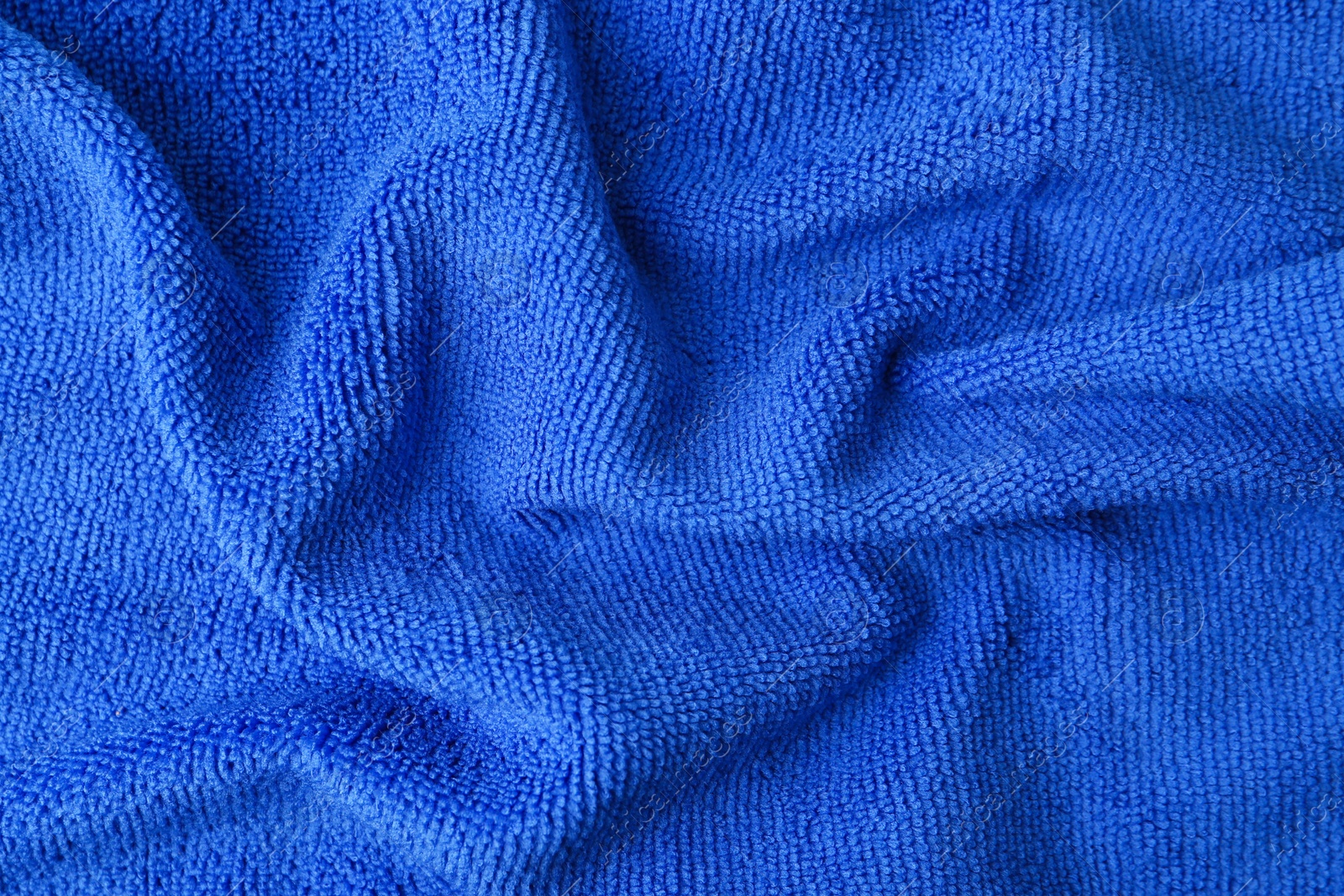 Photo of Clean blue microfiber cloth as background, top view