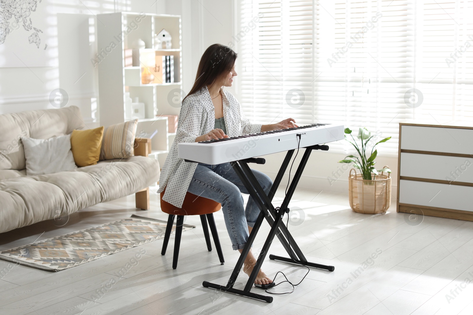 Photo of Woman playing synthesizer at home. Electronic musical instrument