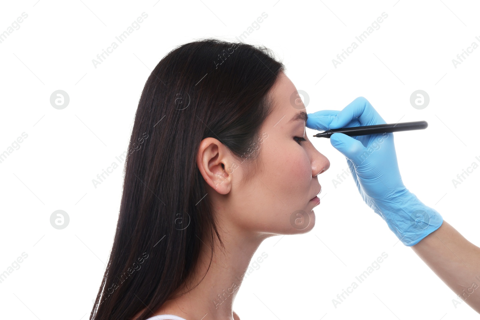 Photo of Doctor drawing marks on patient's nose for plastic surgery operation against white background, closeup