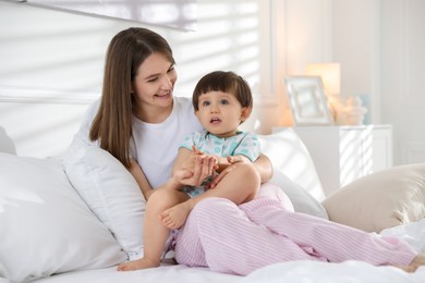 Photo of Happy mother with her little son on bed at home