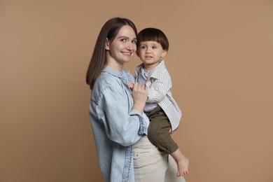 Photo of Family portrait of happy mother with her little son on beige background