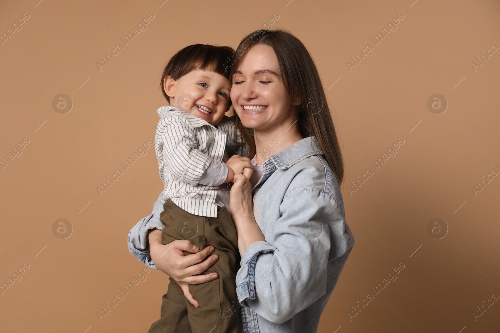 Photo of Family portrait of happy mother with her little son on beige background