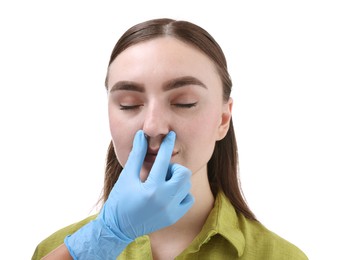 Photo of Doctor checking patient's nose before plastic surgery operation on white background, closeup