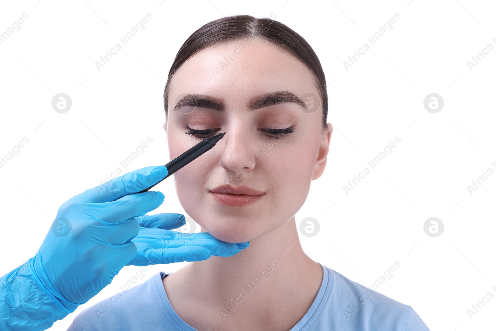 Photo of Doctor drawing marks on patient's nose for plastic surgery operation against white background, closeup