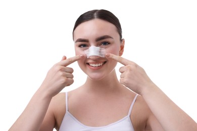 Woman with medical bandage on her nose after plastic surgery operation against white background