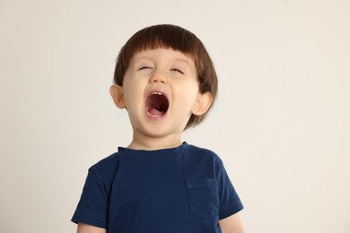 Photo of Portrait of emotional little boy on light grey background