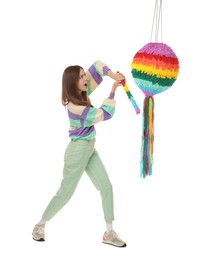 Emotional woman breaking colorful pinata with stick on white background