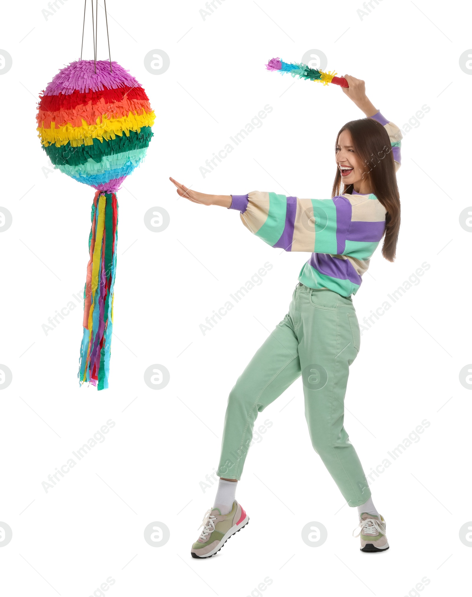 Photo of Happy woman breaking colorful pinata with stick on white background