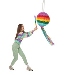 Photo of Emotional woman breaking colorful pinata with stick on white background