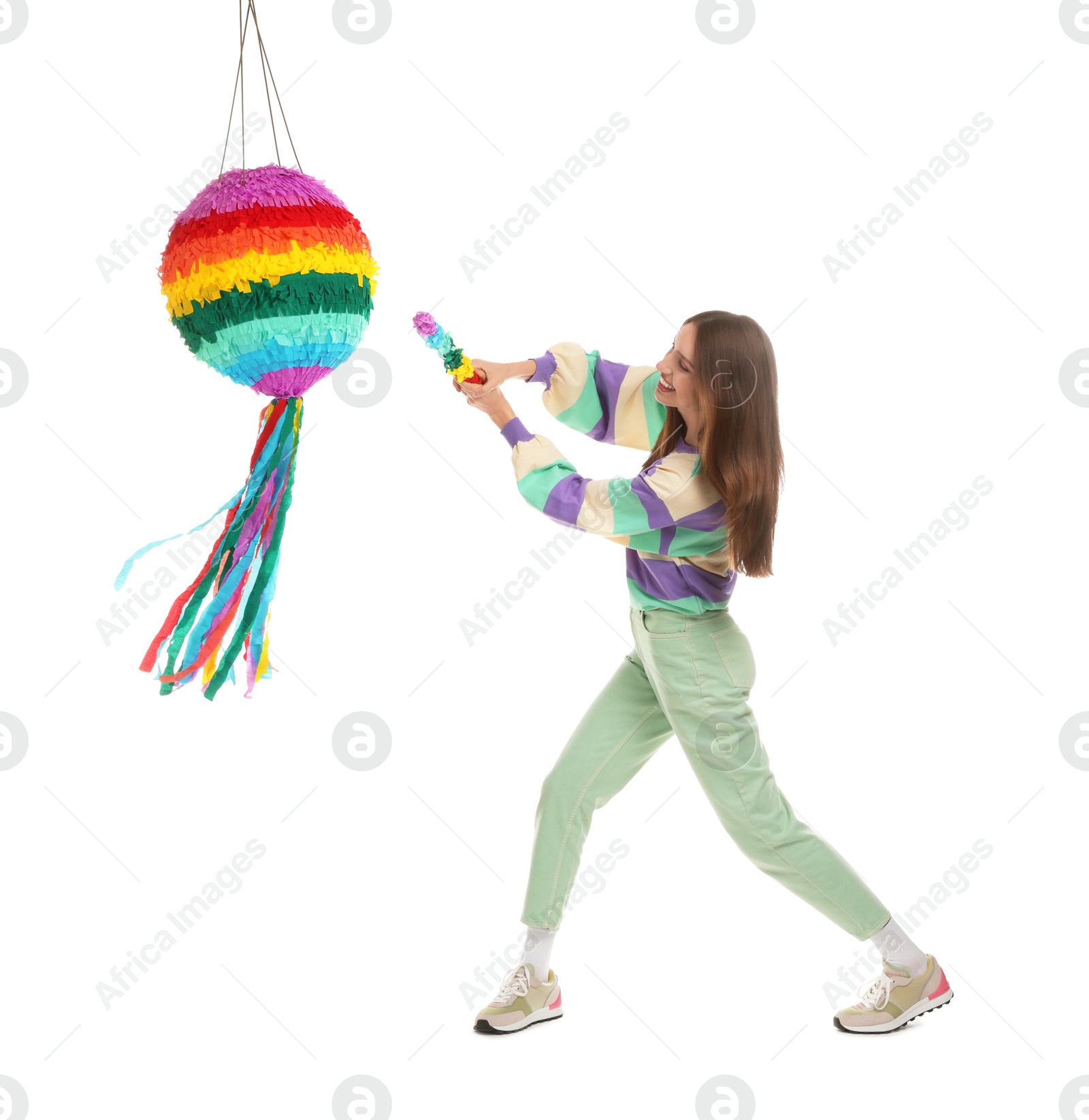 Photo of Happy woman breaking colorful pinata with stick on white background